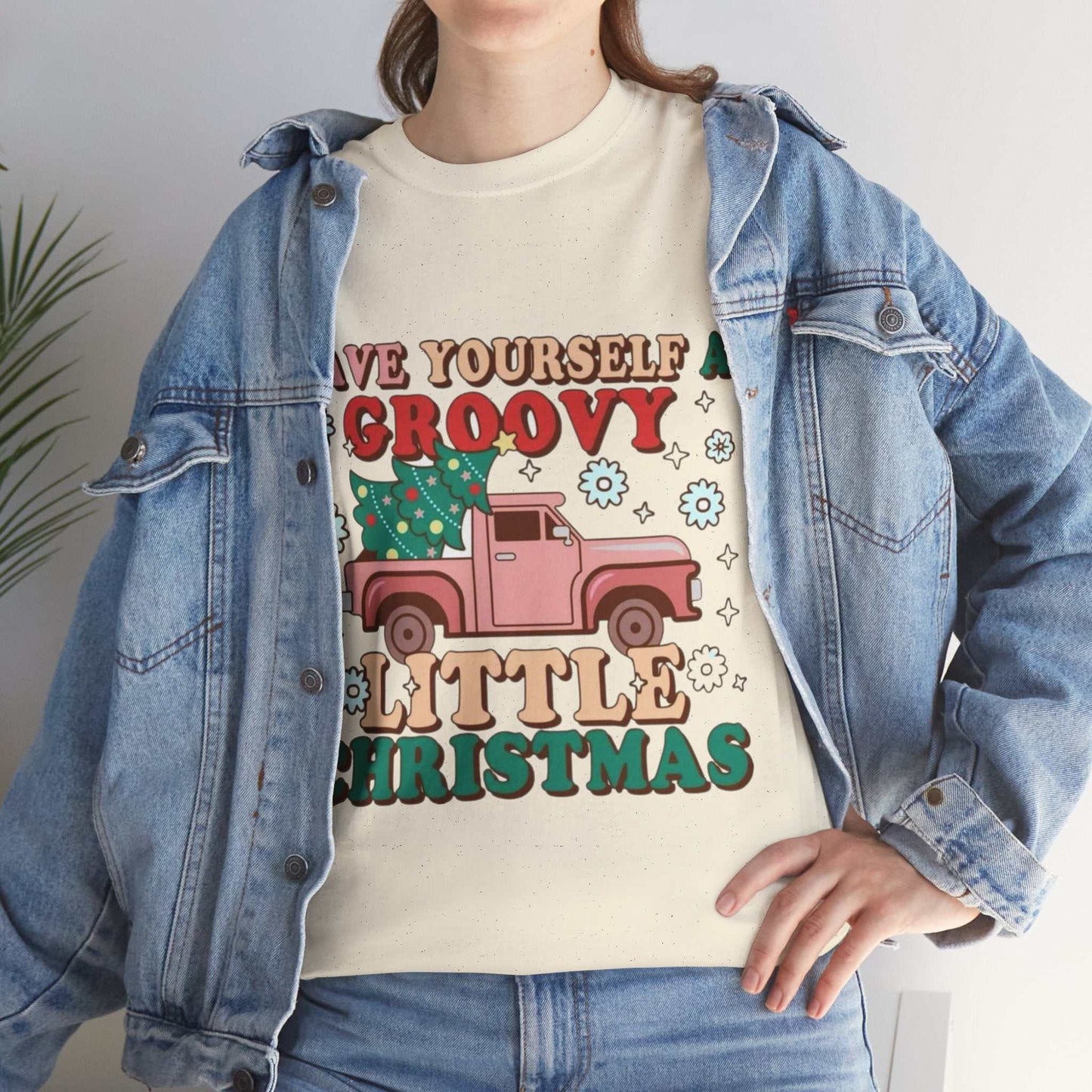 Retro Christmas shirt with "Have Yourself a Groovy Little Christmas" design, featuring festive holiday graphics, worn by a person in a denim jacket.
