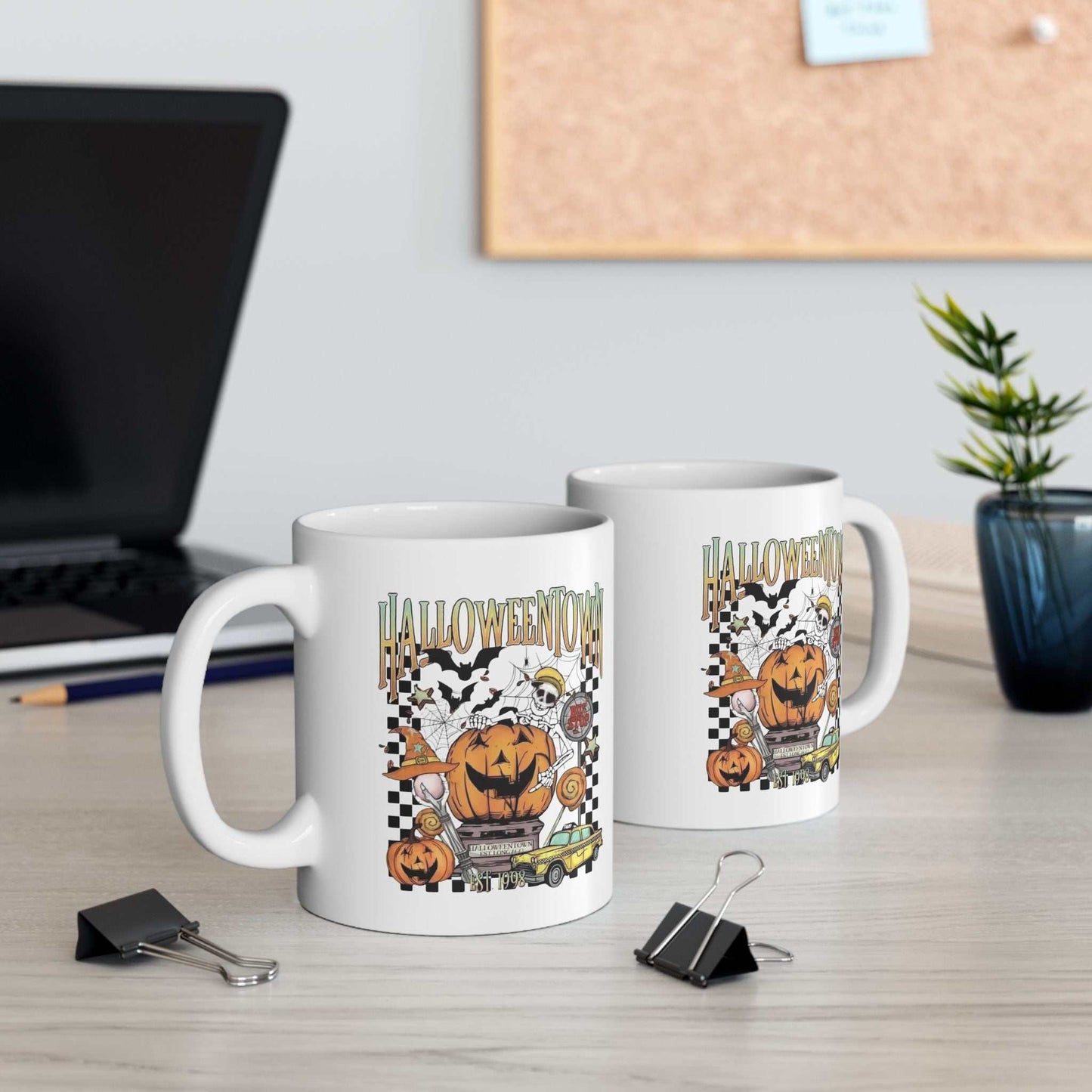 Retro Halloweentown mugs on a desk, featuring vivid Halloween designs, perfect for warm beverages.