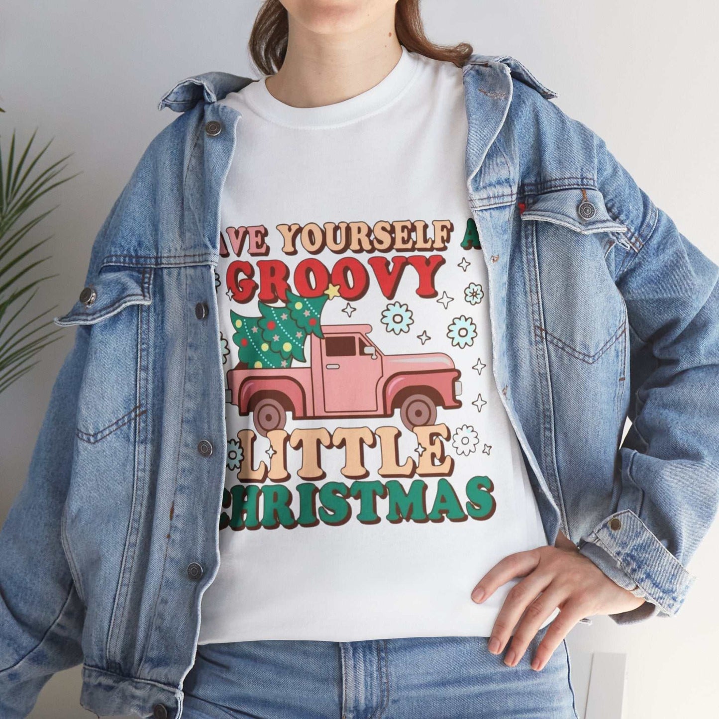 Retro Christmas shirt with festive groovy design featuring a pink truck, worn under a denim jacket.