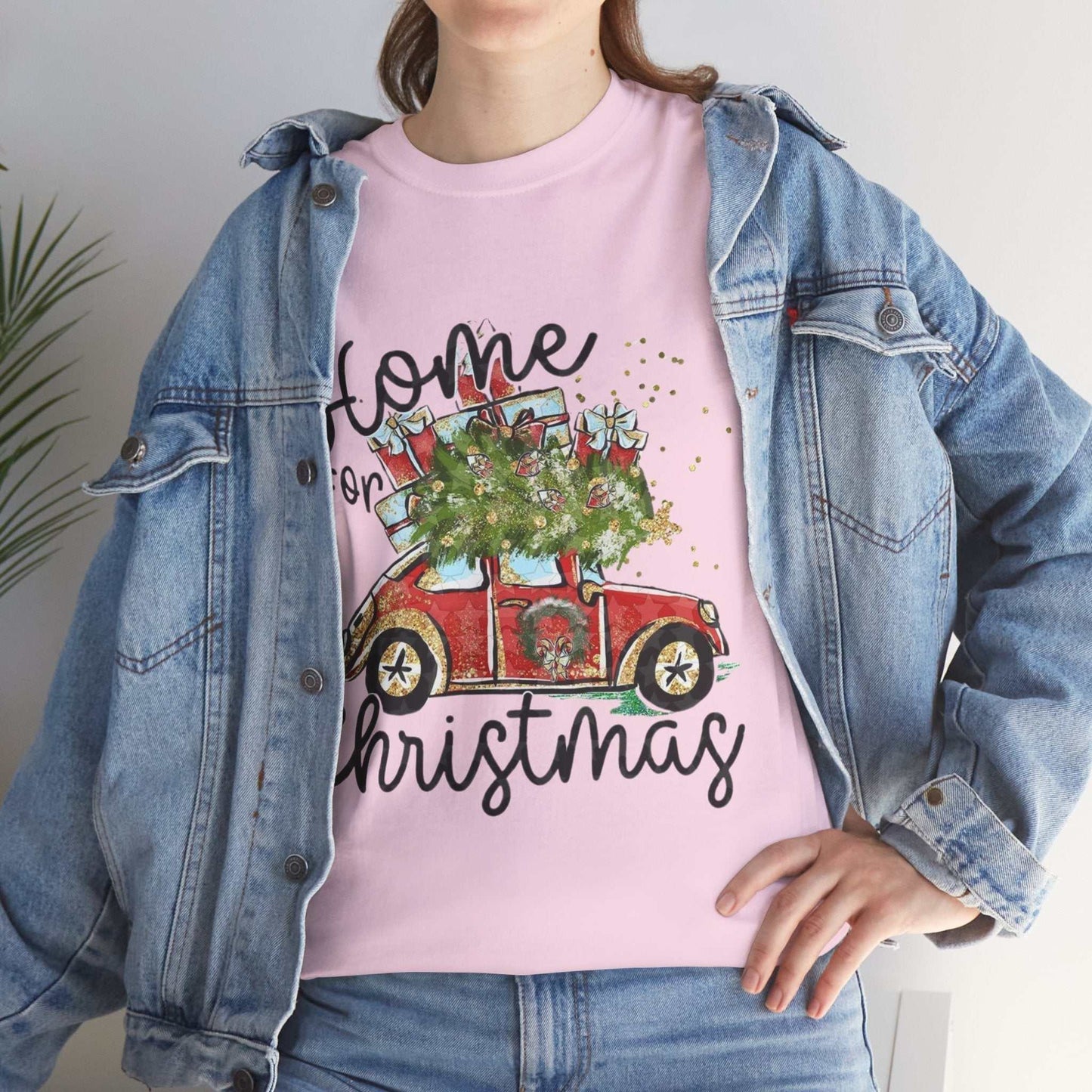 Cozy pink Home for Christmas Shirt with festive car design under denim jacket.