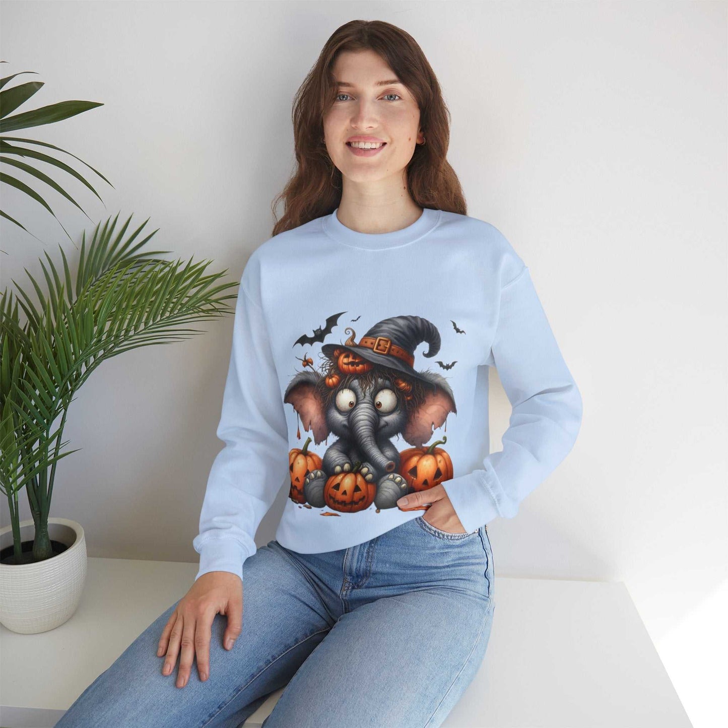 Woman wearing a Funny Elephant Halloween Sweetshirt with pumpkins and bats design.
