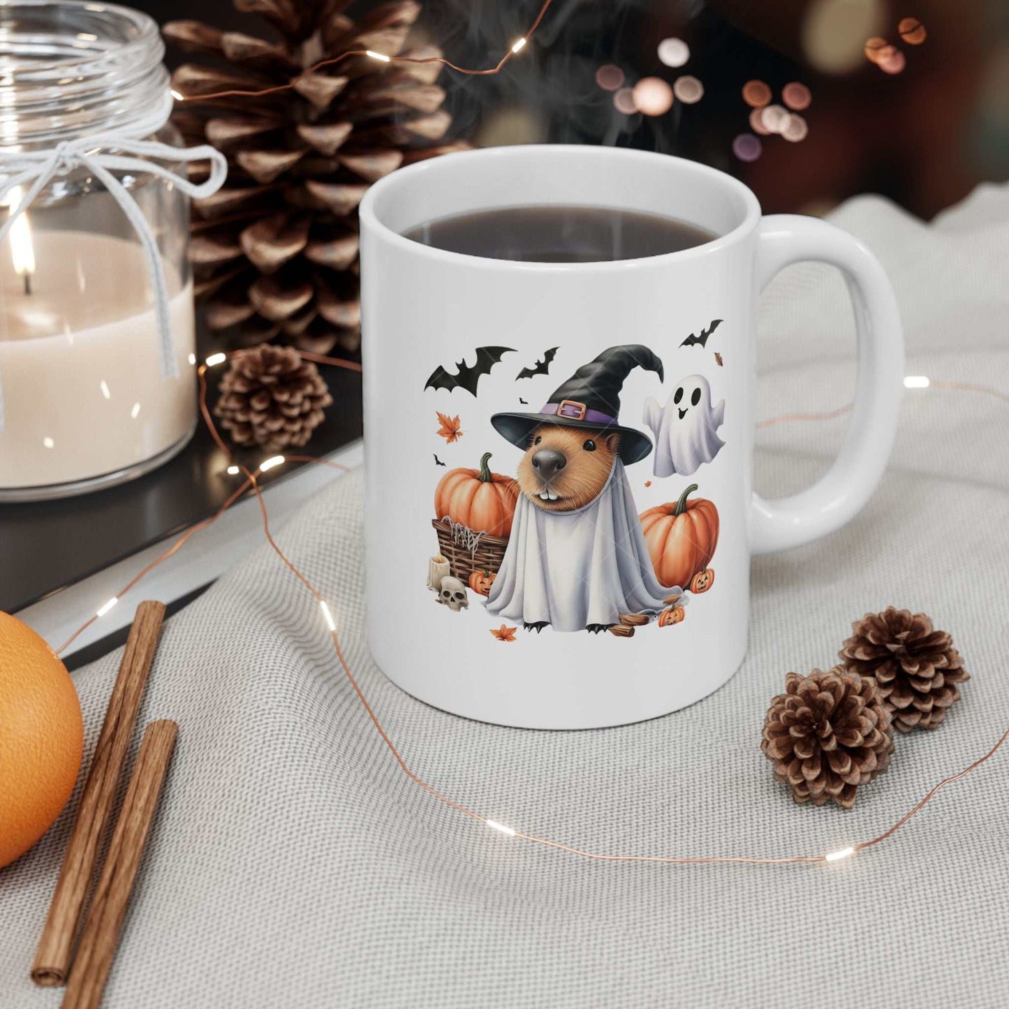 Halloween Capybara Mug with witch hat and ghost design, surrounded by pumpkins and spooky decorations.