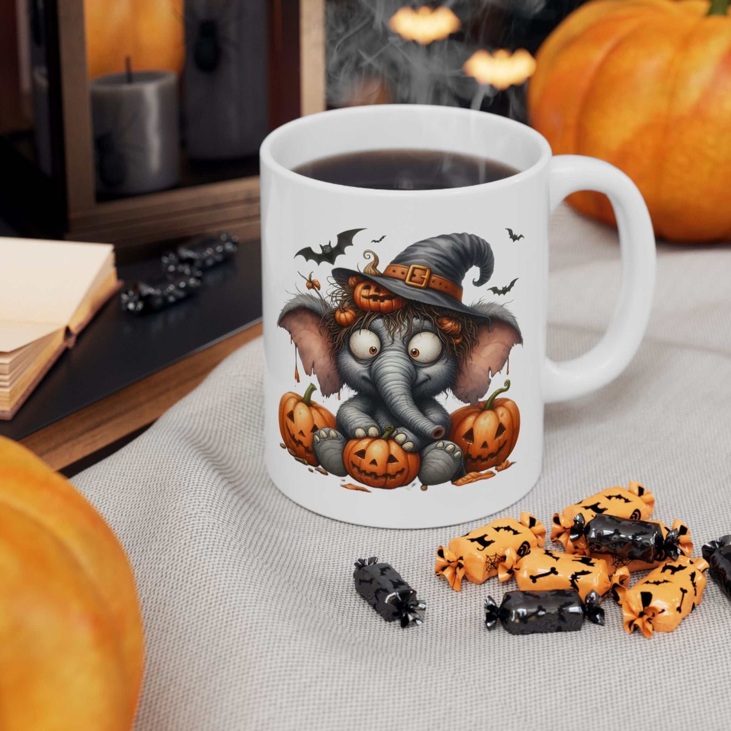 Funny Elephant Halloween Mug with cute spooky design featuring an elephant in a witch hat surrounded by pumpkins.