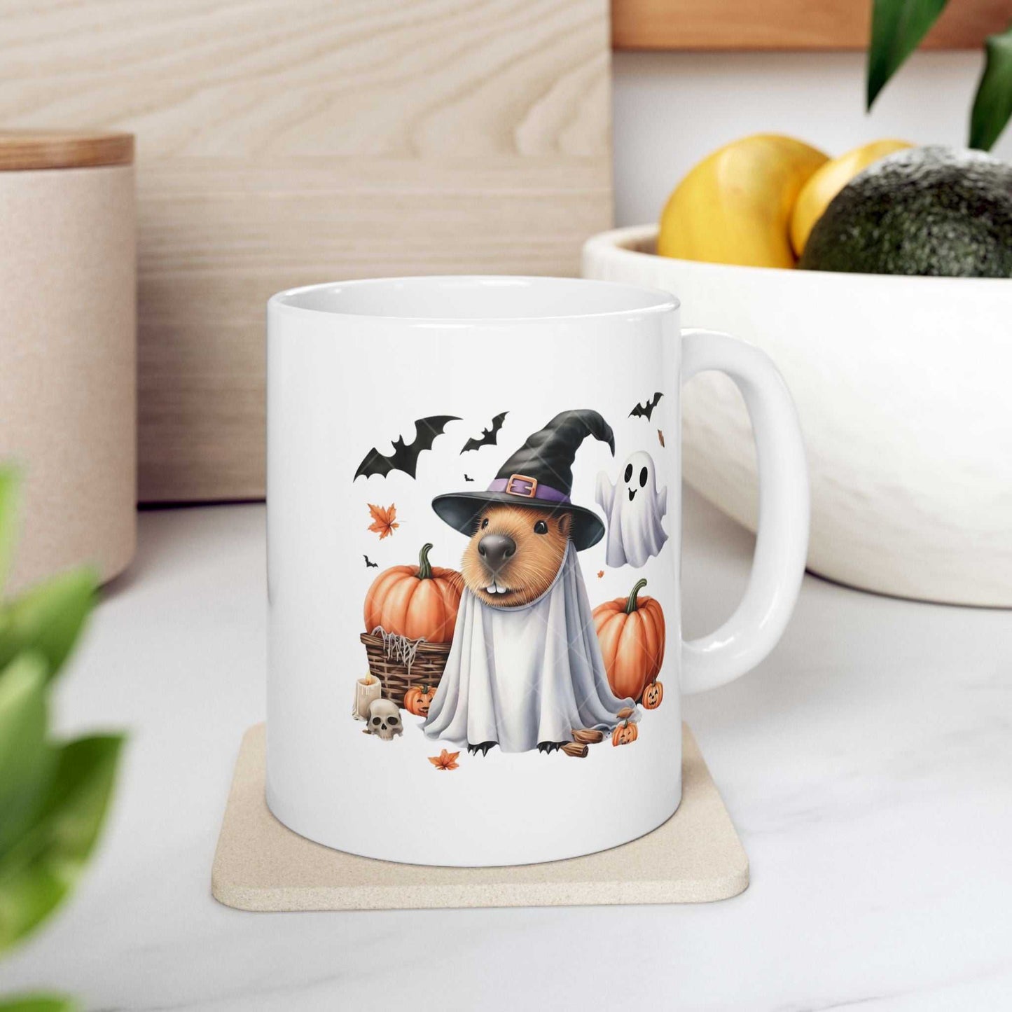 Ceramic mug featuring a Halloween-themed capybara in a witch costume with pumpkins and ghosts.