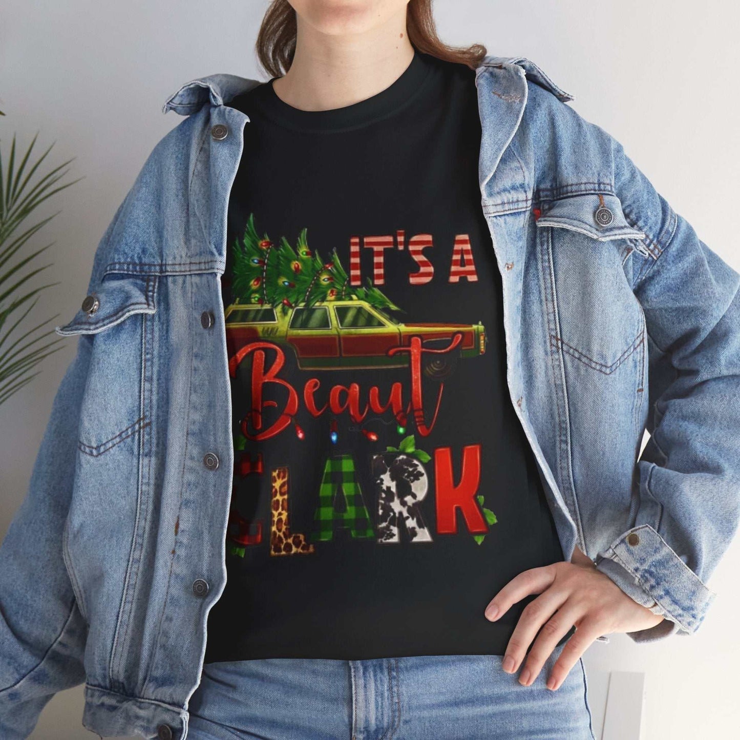Retro "It's A Beaut Clark" Christmas shirt featuring vintage holiday design on black tee with denim jacket.