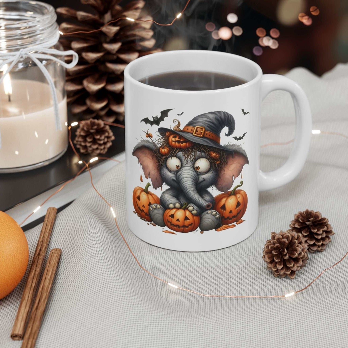 Funny elephant Halloween mug with spooky design and pumpkins.