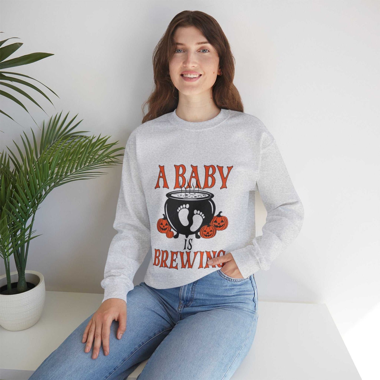 Unisex "A Baby Is Brewing" sweatshirt, Halloween pregnancy announcement design.