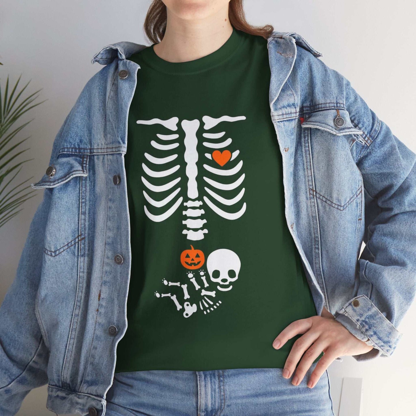 Halloween maternity shirt with white skeleton design and pumpkin graphic on green tee.
