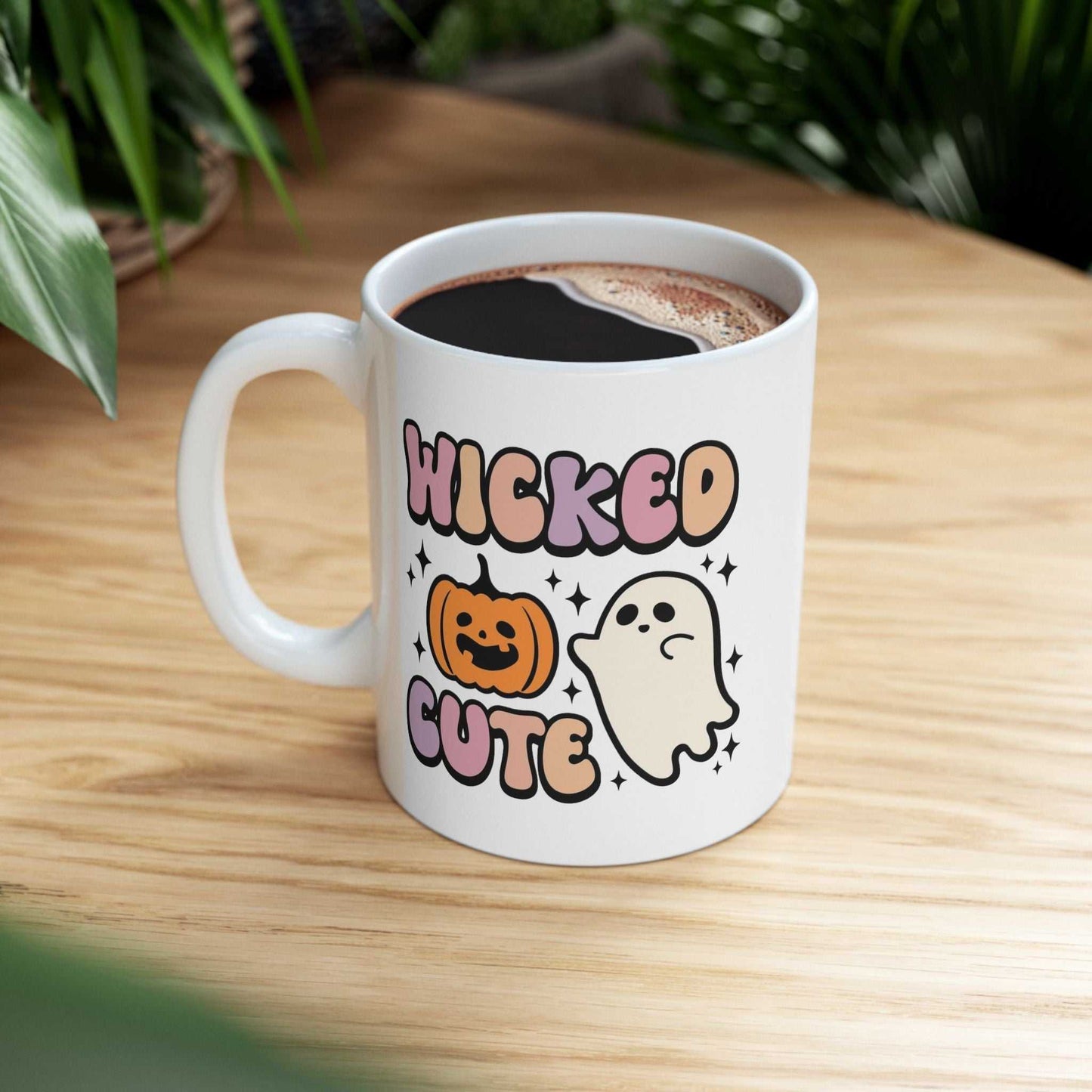 Wicked Cute Halloween mug with pumpkin and ghost design on a wooden table.