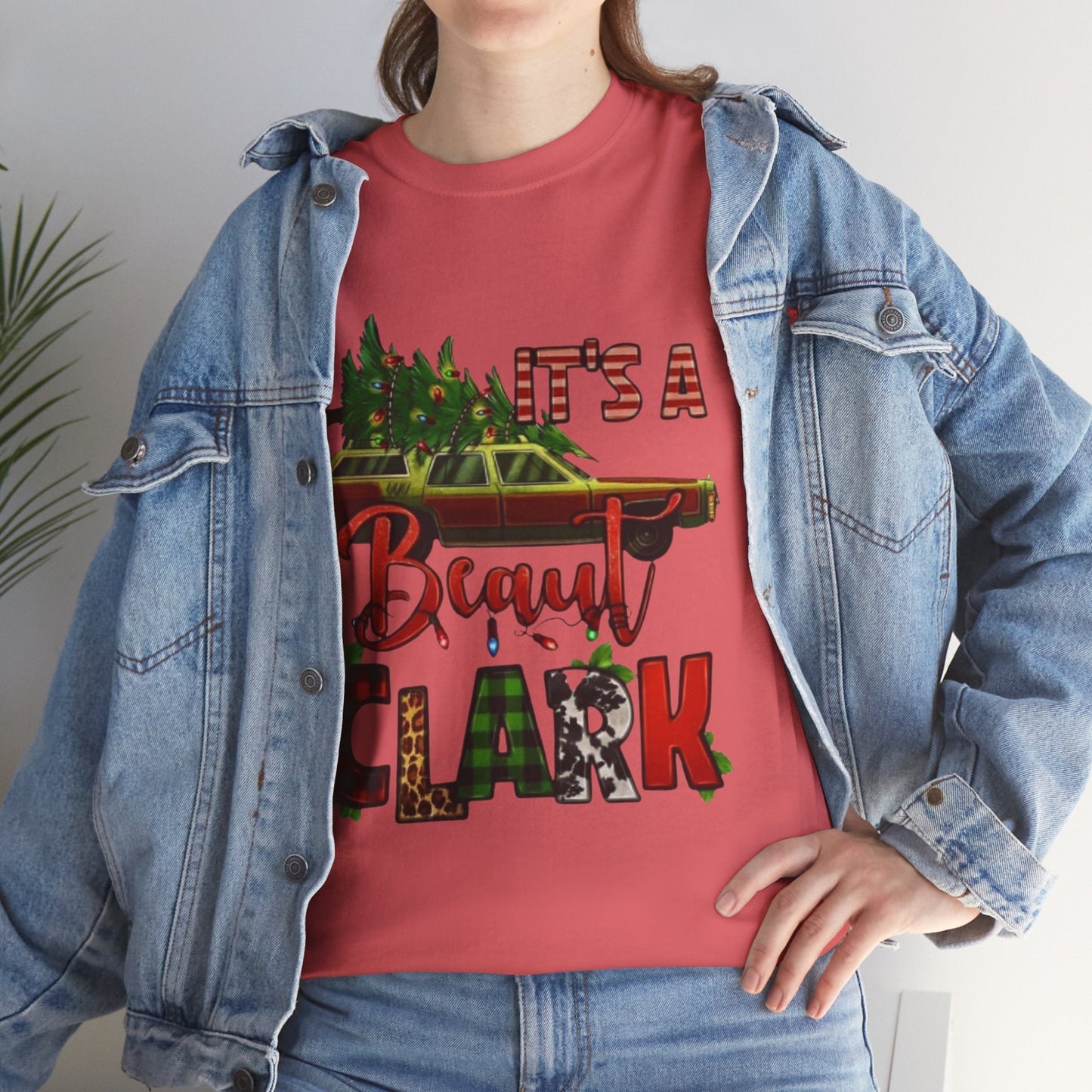Retro "It's A Beaut Clark" Christmas Shirt, inspired by National Lampoon's Christmas Vacation, displayed on a person wearing a denim jacket.