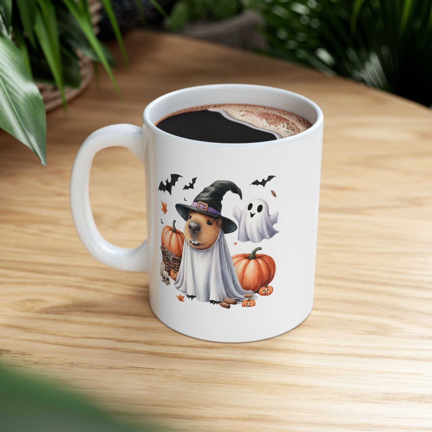 Ceramic coffee mug featuring a Halloween-themed capybara with a witch hat and pumpkins, ideal for spooky season fans.