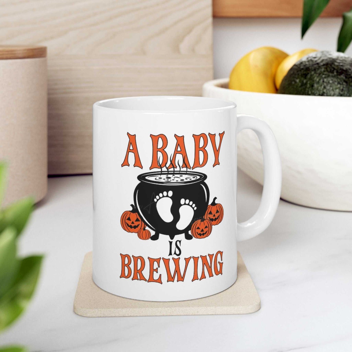 Ceramic coffee mug with "A Baby is Brewing" design, perfect for Halloween pregnancy announcements.