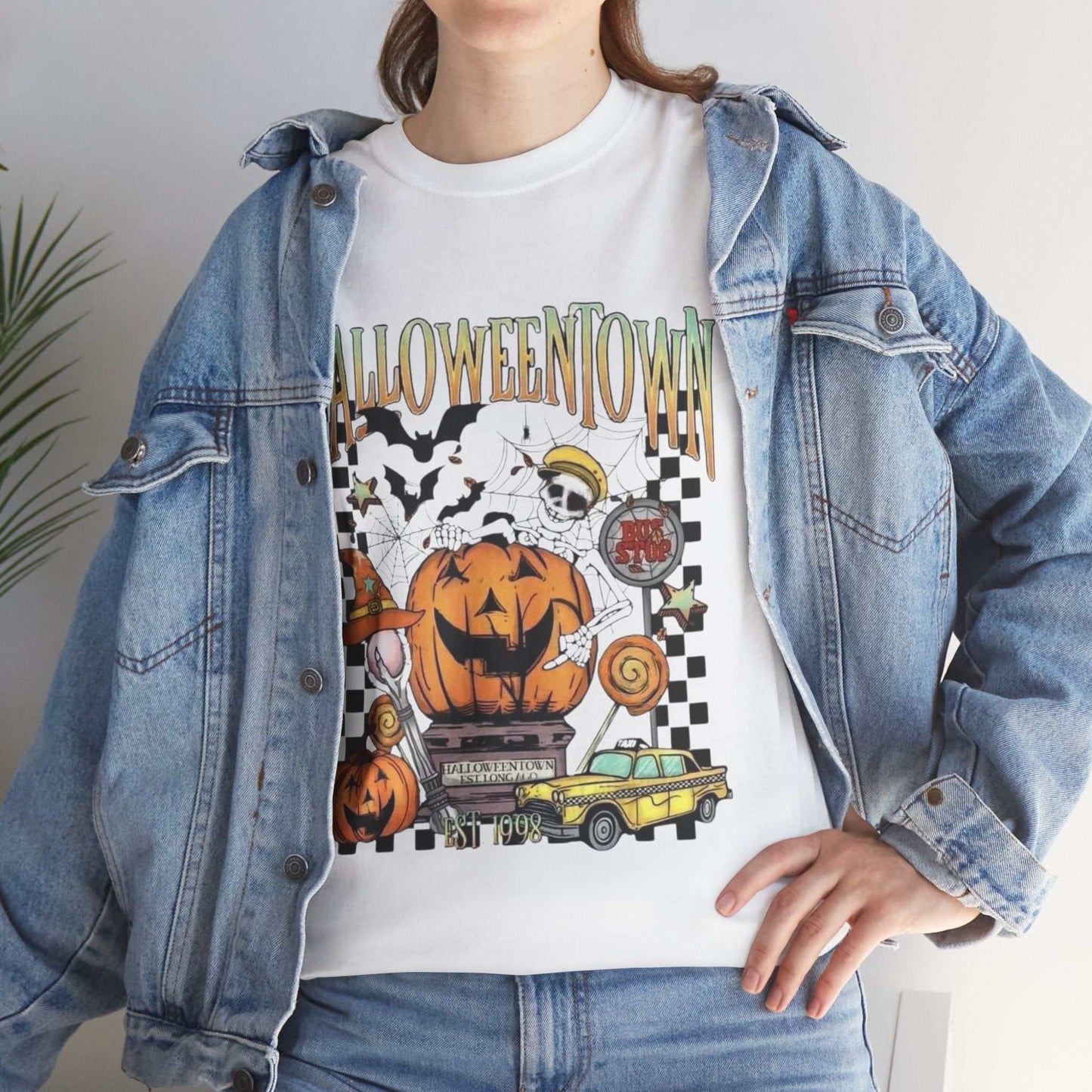 Retro Halloweentown Shirt with spooky design, worn under a denim jacket, featuring pumpkins and ghosts.