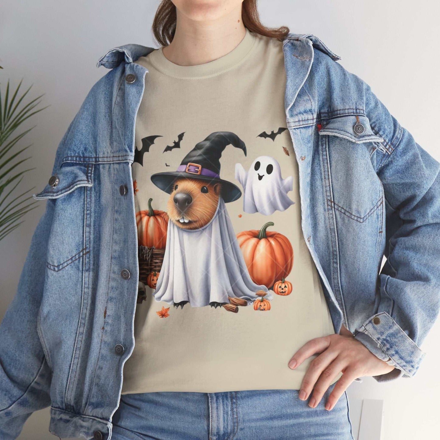 Halloween Capybara Shirt with spooky capybara print, pumpkins, ghost, under a denim jacket.