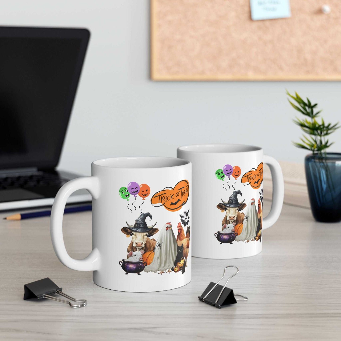 Trick or Treat Halloween Mugs on desk, featuring festive spooky design with cows and pumpkins, perfect for Halloween festivities.