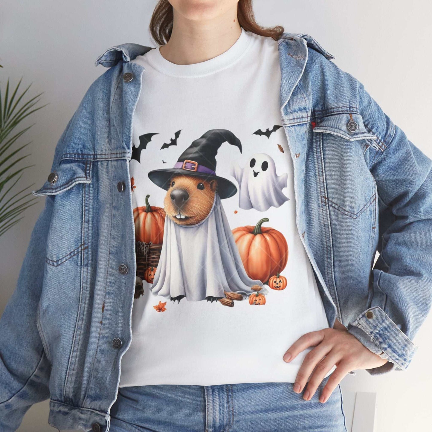 Halloween capybara shirt with spooky design featuring capybara in witch hat, pumpkins, bats, and ghost.
