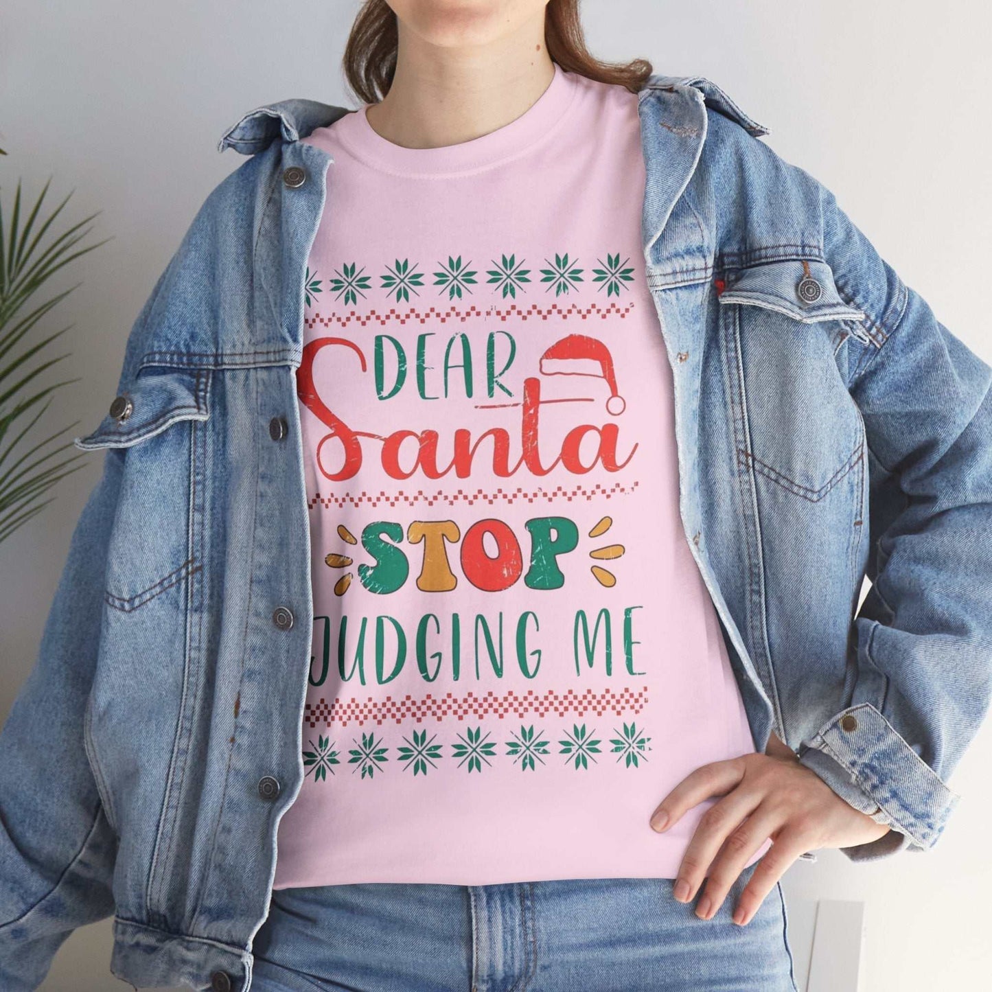 Funny pink Christmas shirt with "Dear Santa Stop Judging Me" slogan, worn with denim jacket, great holiday gift.