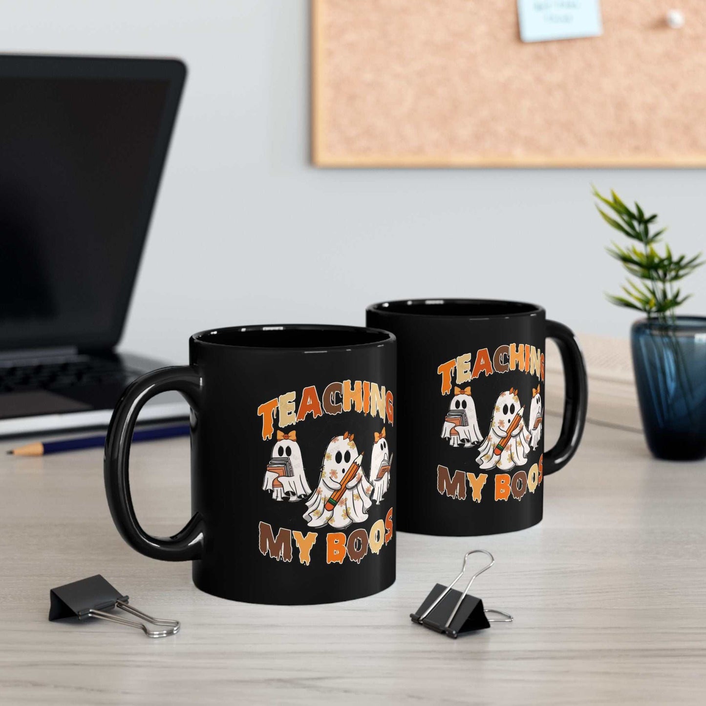 Black ceramic "Teaching My Boos" mug with ghost design, perfect for Halloween-loving teachers.