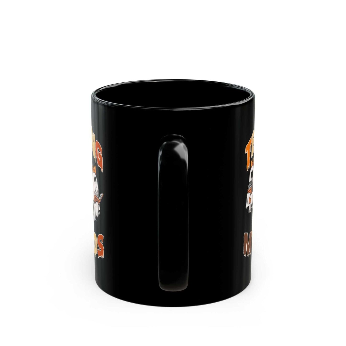 Black ceramic mug with "Teaching My Boos" Halloween design and ghost graphic.