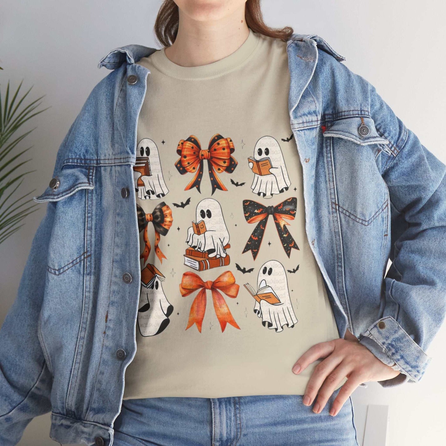 Woman wearing Book Ghost Halloween Shirt with ghost and bow designs, layered under a denim jacket.