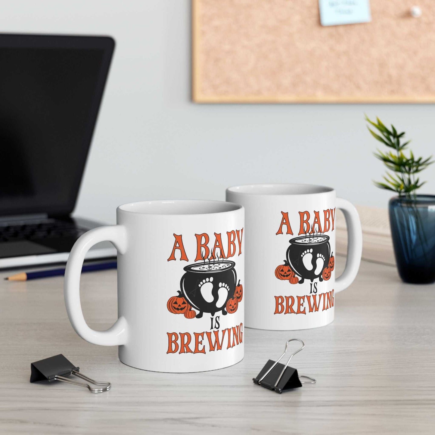 Halloween-themed "A Baby is Brewing" mugs for pregnancy announcements.