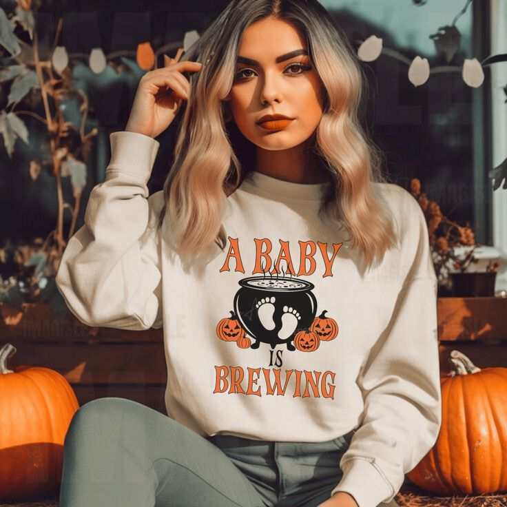 Unisex crewneck sweatshirt with "A Baby Is Brewing" design, ideal for Halloween pregnancy announcements.